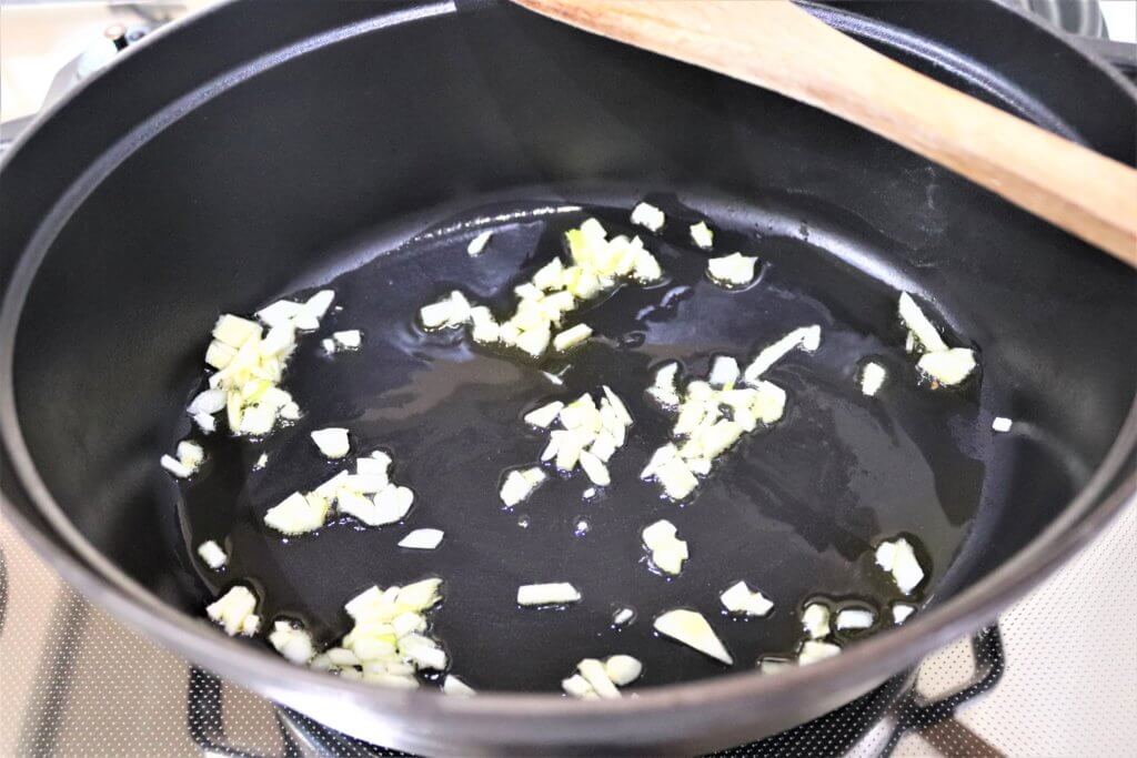 油を敷いた鍋でニンニクが炒められている様子