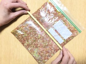 空気を抜きながら平たくし、菜箸などで６等分になるよう筋をつける。（筋をつけておくことで、冷凍保存をした際に作りたい分量を取り出しやすくなります。
