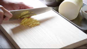 １.しょうがは千切りにし、大根は皮を剥いて１cm厚さの半月切りにする。