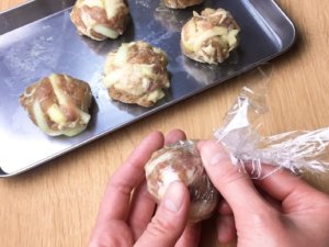 ６等分してラップなどでぎゅっと絞って丸め、フライパンにサラダ油を中火で熱し、丸めた肉だねを並べ入れる。